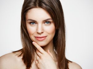 nude young beautiful woman with natural make up smiling cosmetology and spa facial treatment